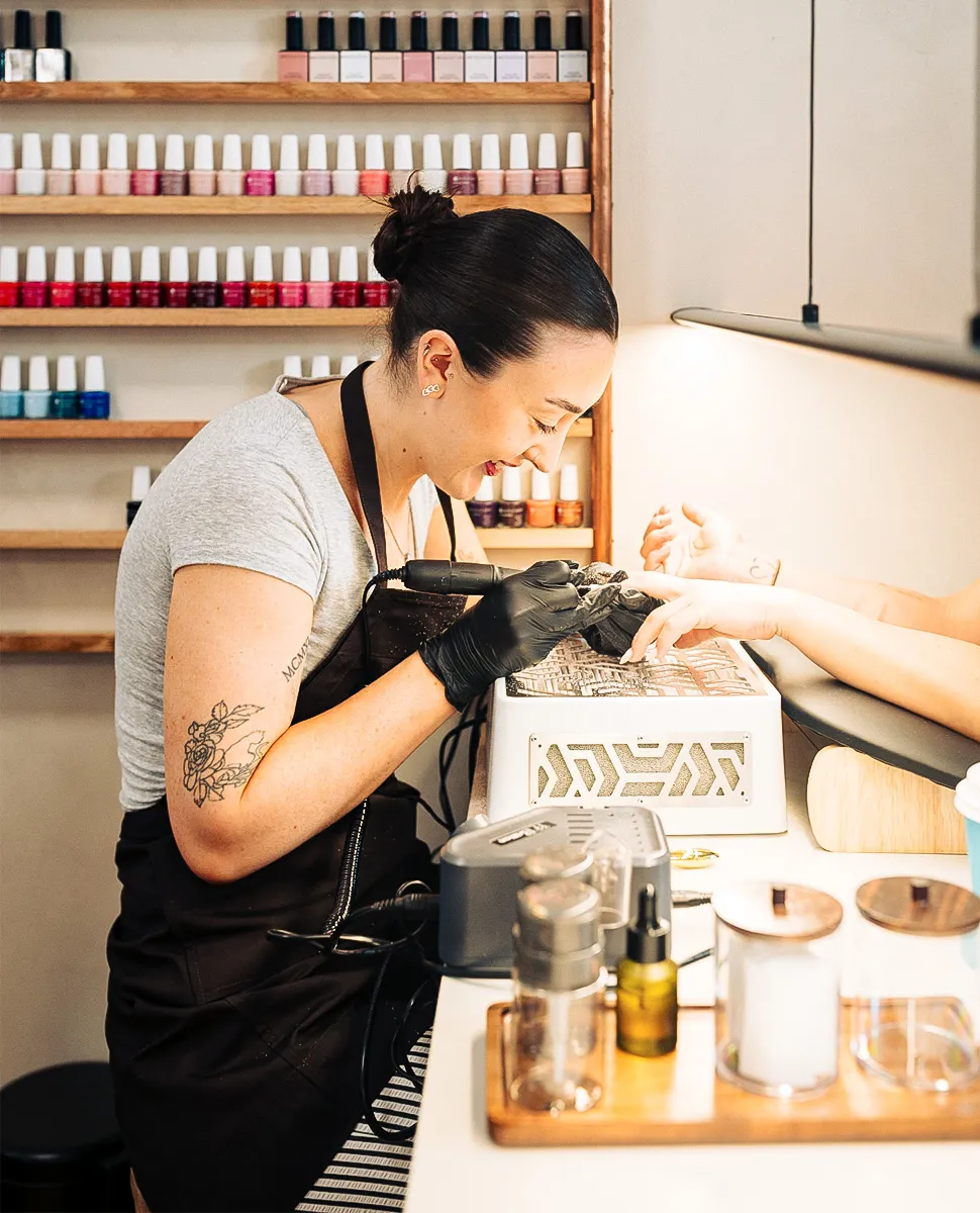 Nail technician working on a client's manicure at Olaya & Co., Byron Bay