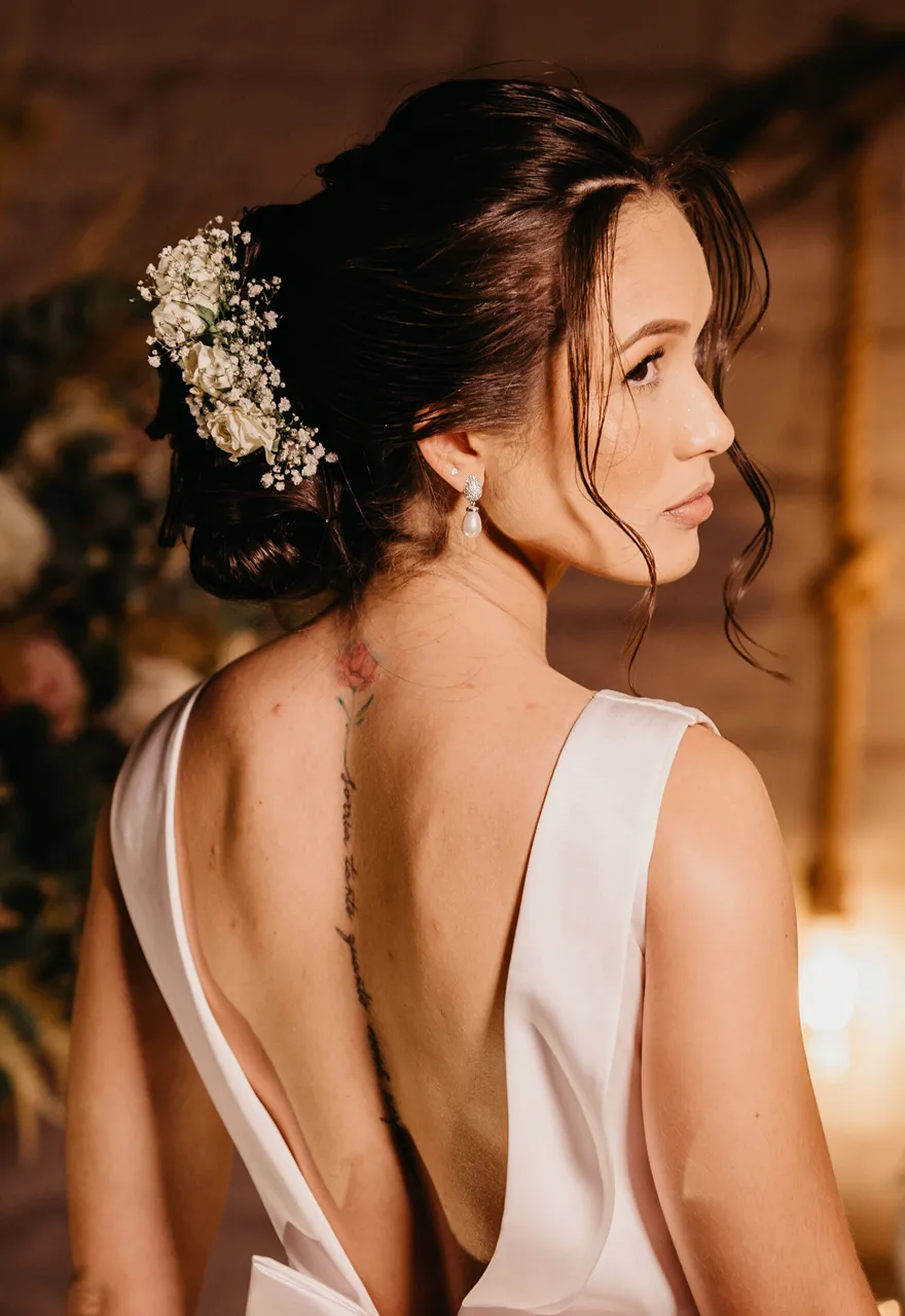 Bride with a soft floral updo by Olaya & Co., Byron Bay, wearing a low-back satin gown