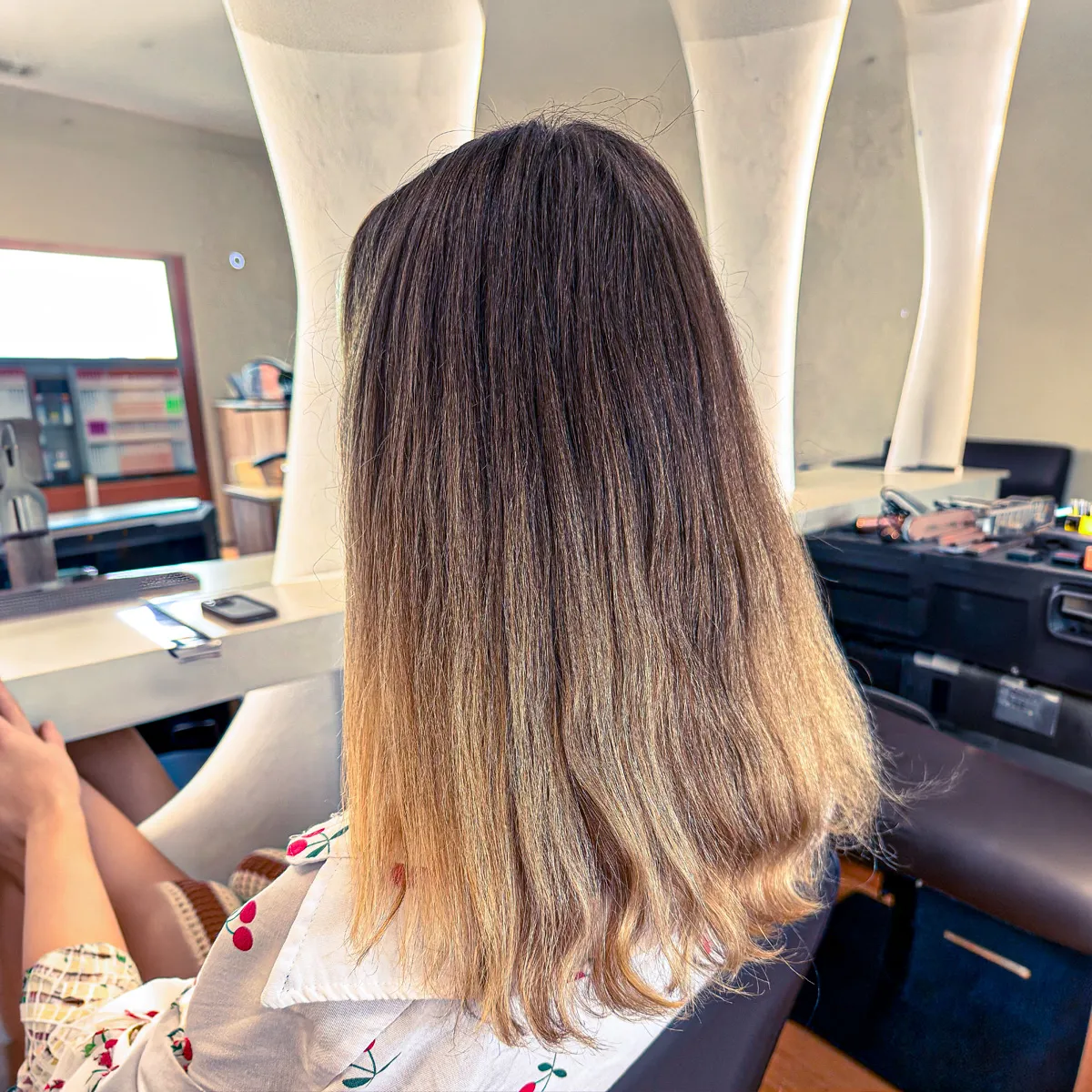 Shoulder-length bright blonde highlights with a soft shadow root, styled sleek and straight — before