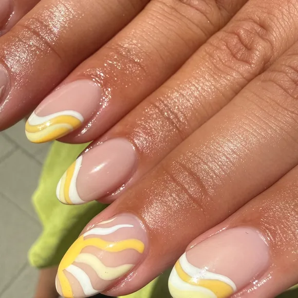 Close up of almond nails with yellow and white swirl tips