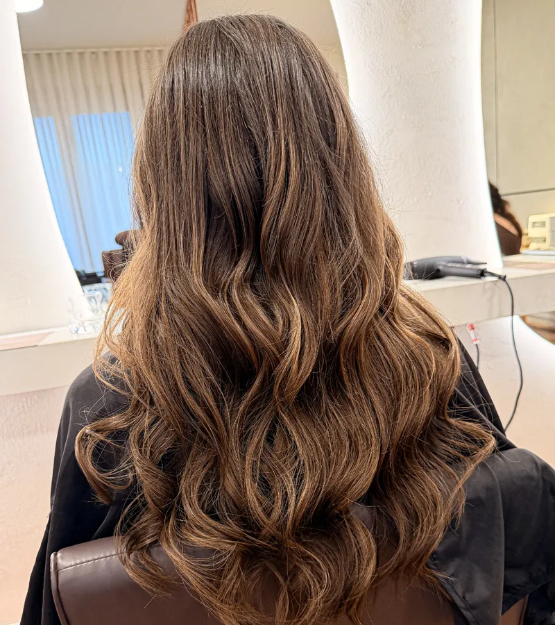 Client with sleek dark curls and statement earrings