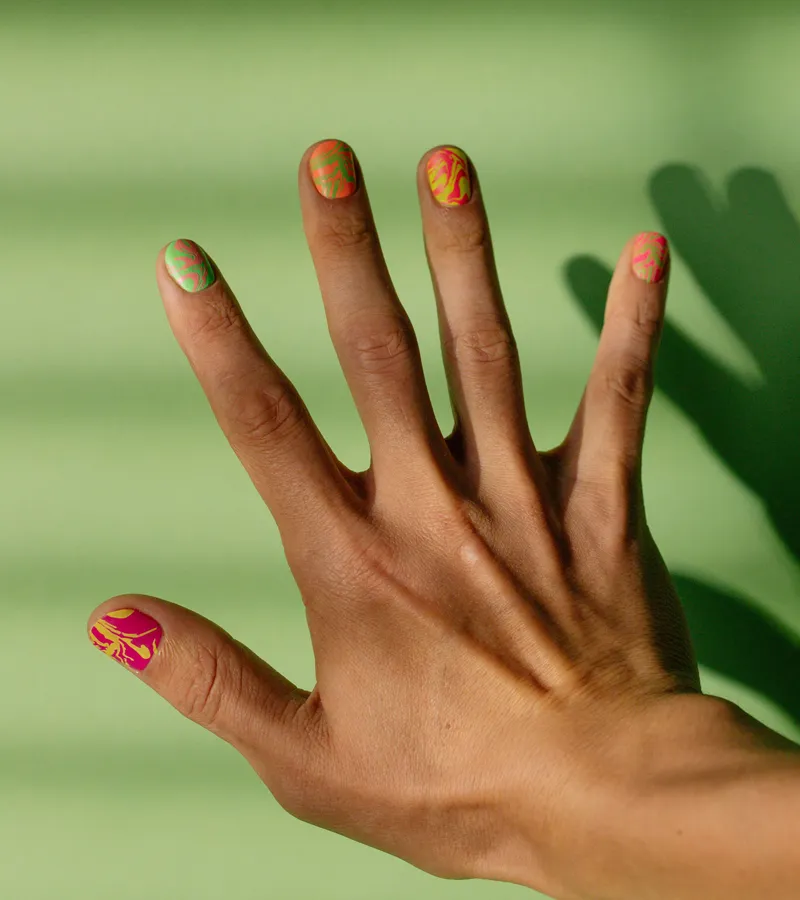 Short rounded nails in soft baby pink, hands against white dried florals