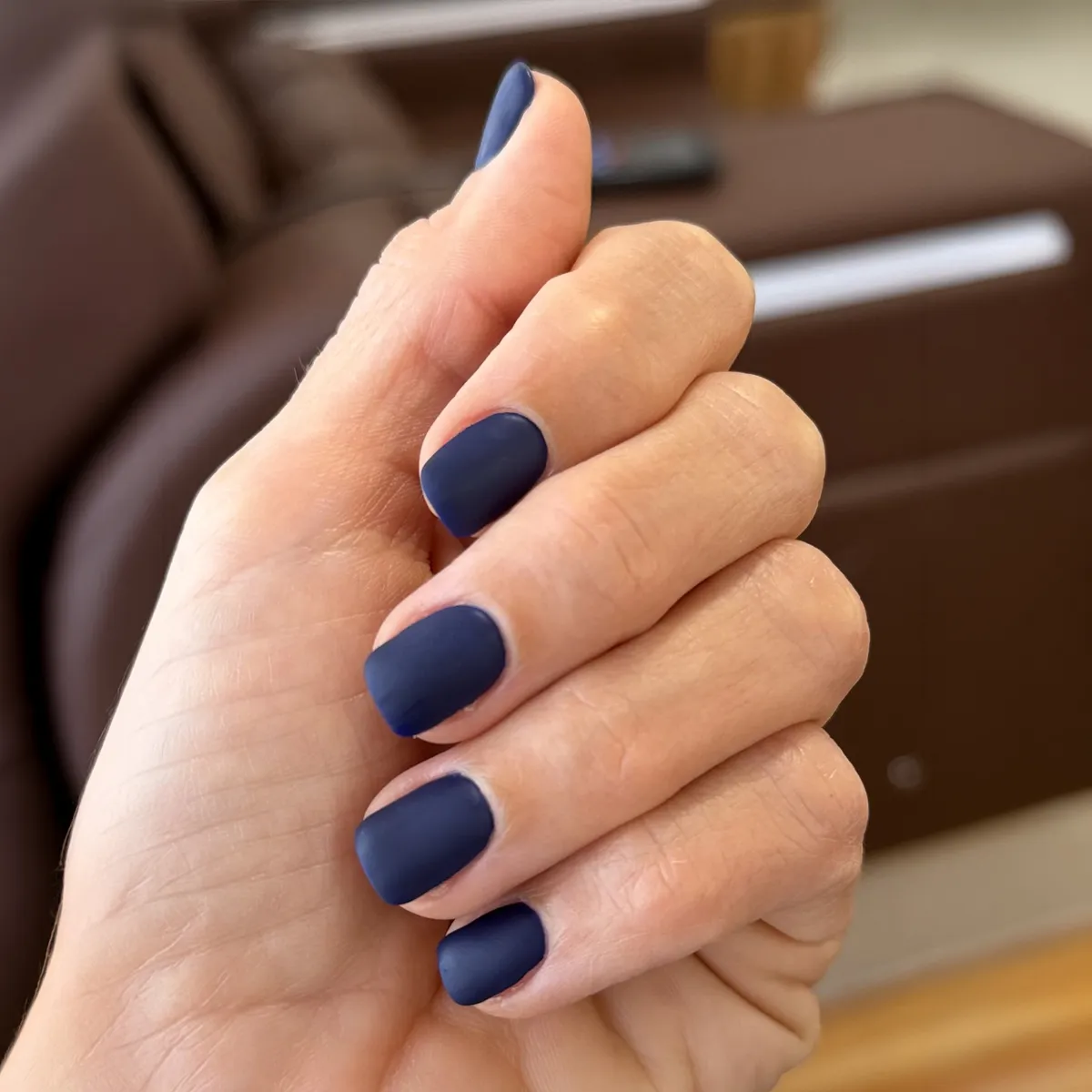 Short, square manicure on healthy nails, finished in long-lasting matte navy polish — after