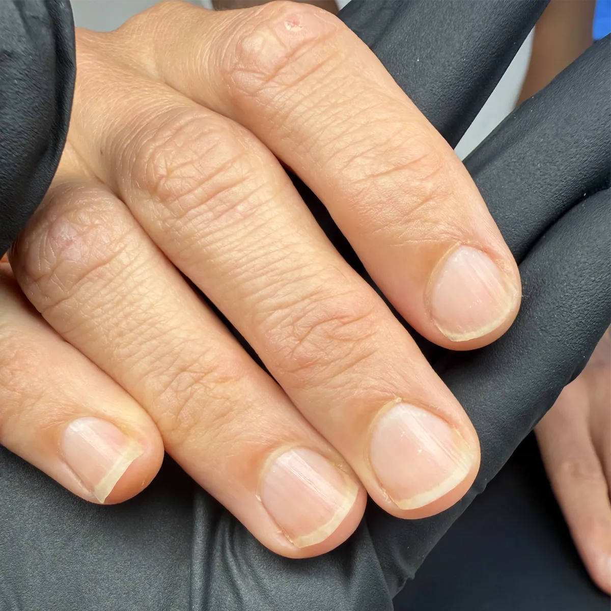 Short, square manicure on healthy nails, finished in long-lasting matte navy polish — before