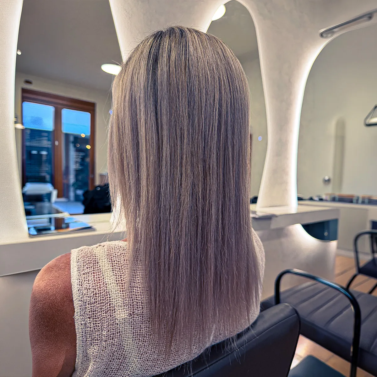 Smooth, frizz-free ash blonde hair with a glossy finish following a nanoplasty treatment — after