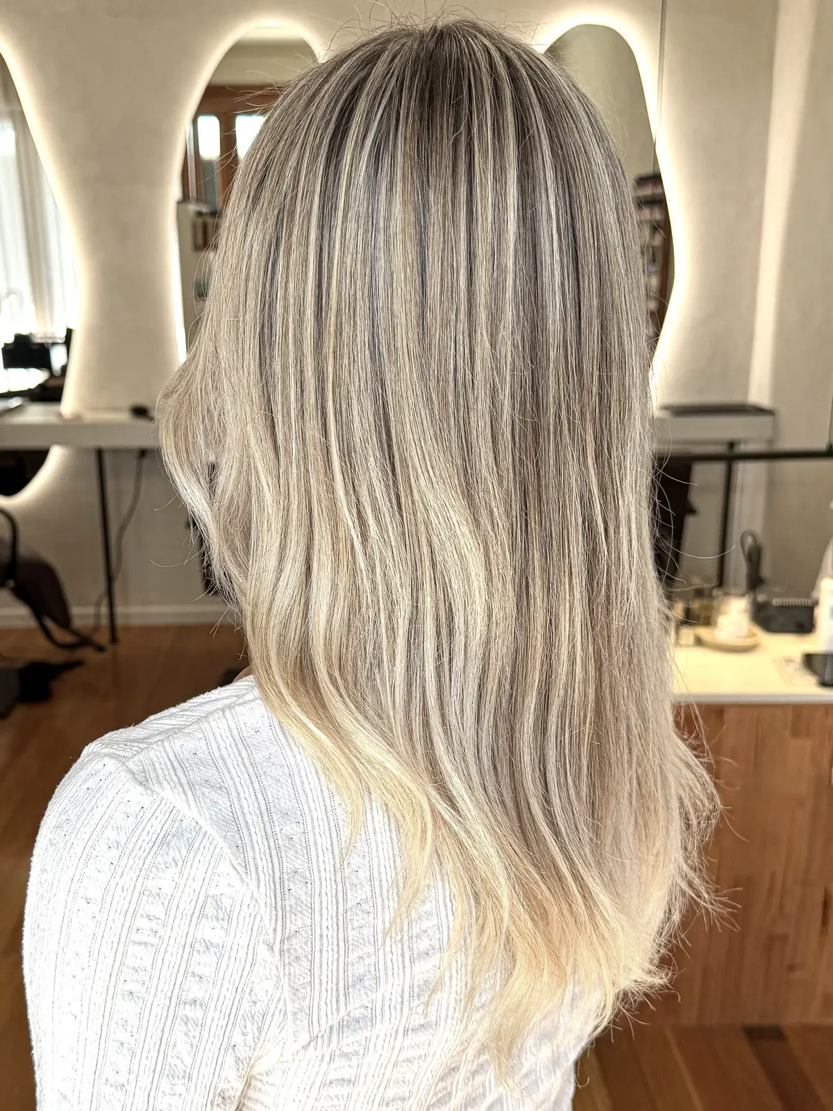 Mid-length ash blonde balayage with a soft, lived-in root