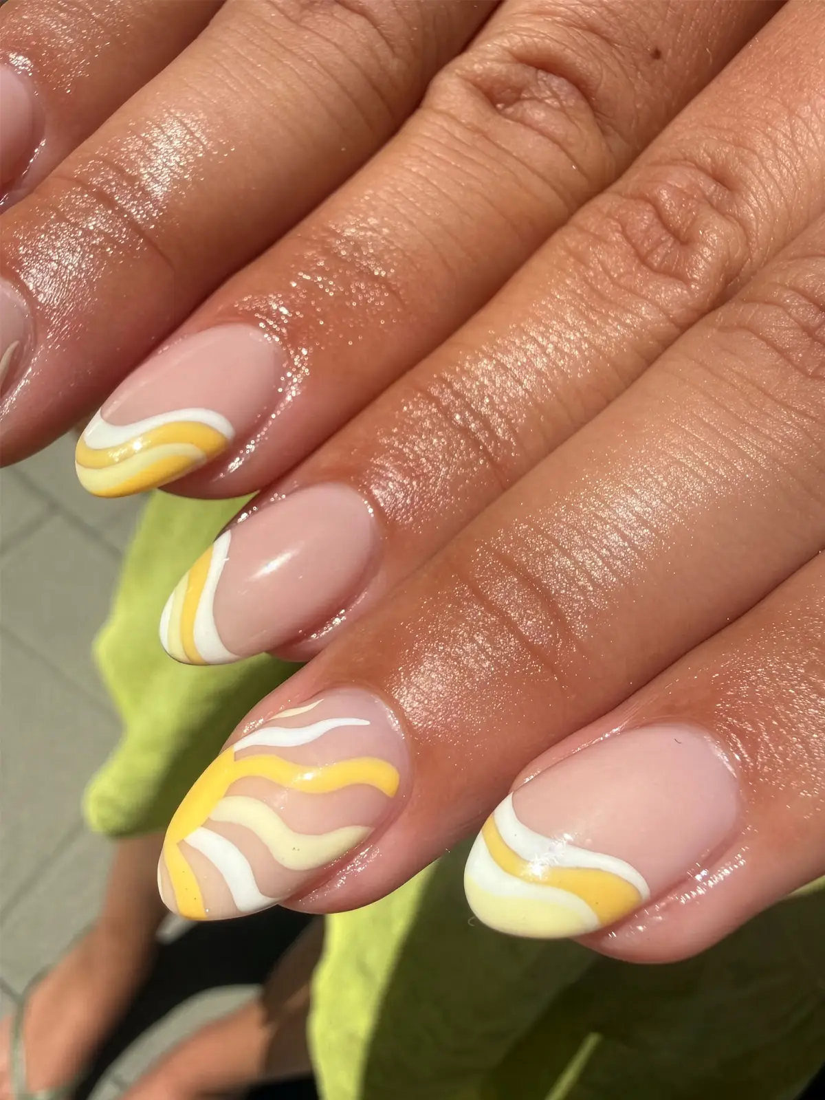 Almond-shaped nude nails with retro yellow and white swirl art