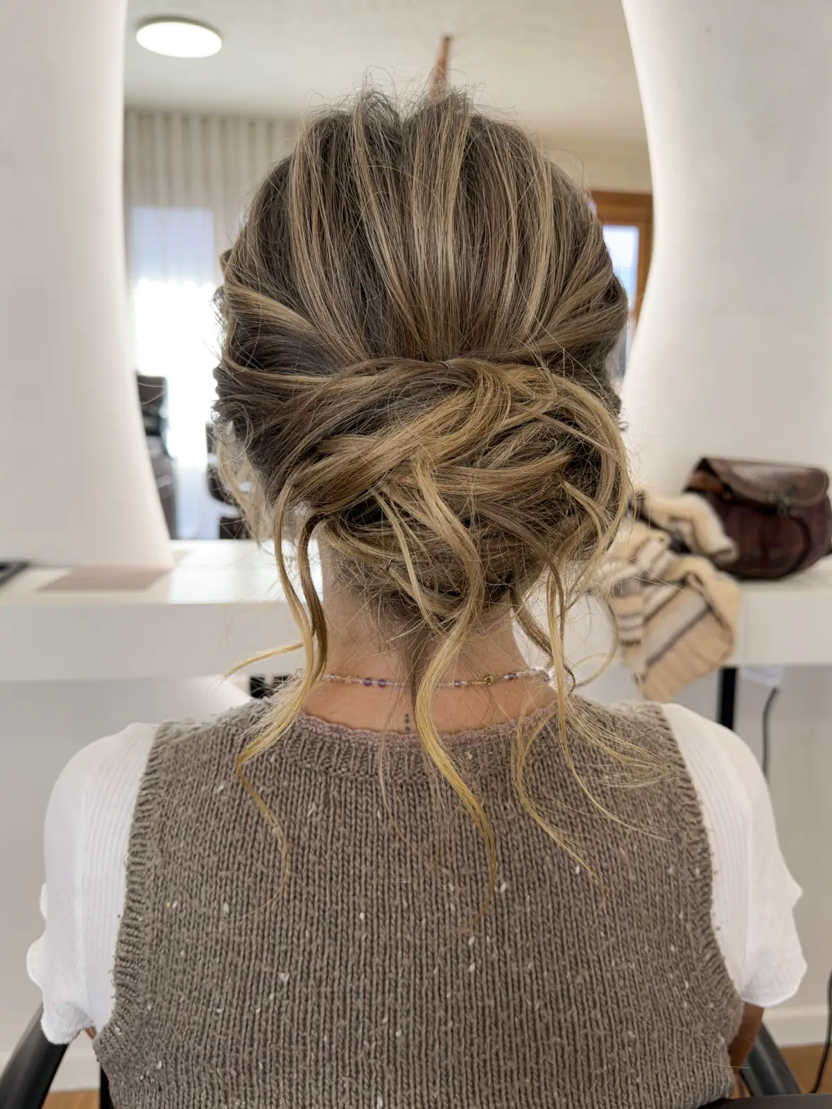 Textured low bun updo with loose, face-framing pieces