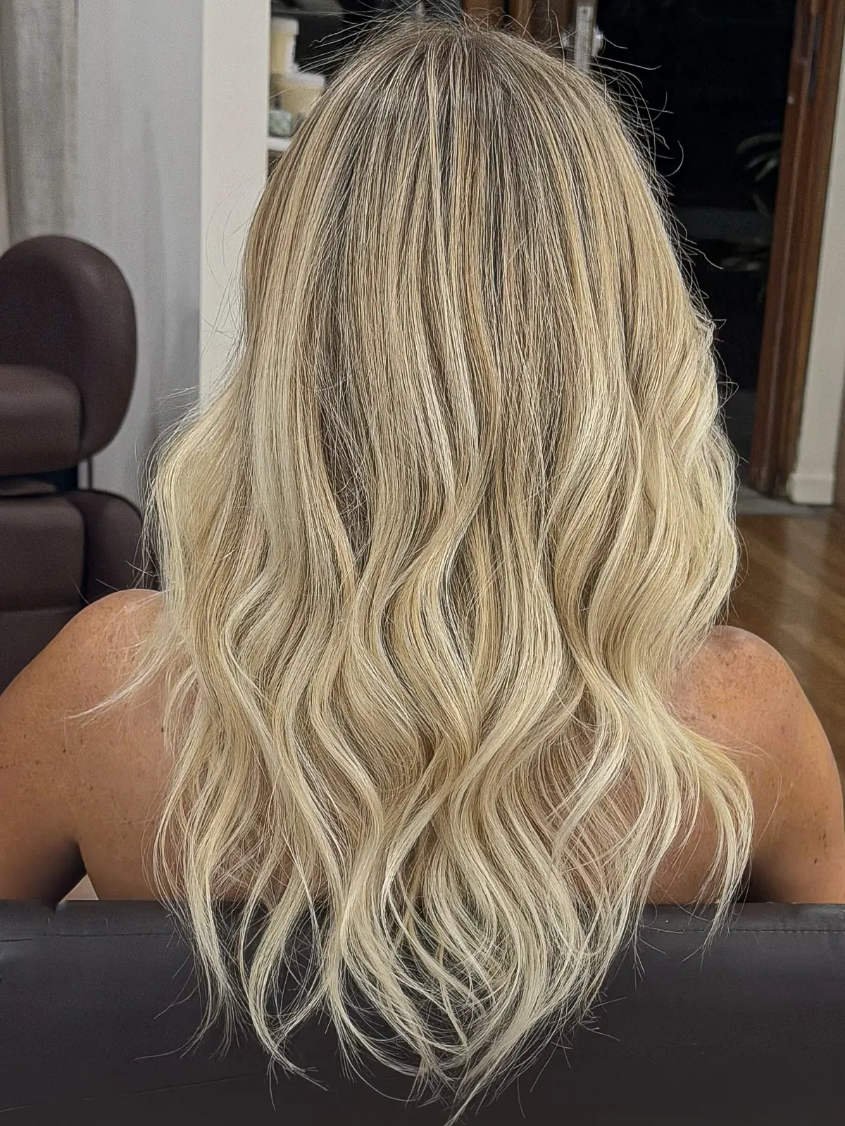 Long creamy blonde hair styled in soft beach waves